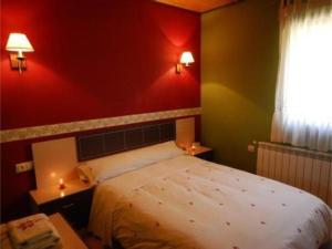 ein Schlafzimmer mit einem großen Bett und einer roten Wand in der Unterkunft El Olivar in Palo