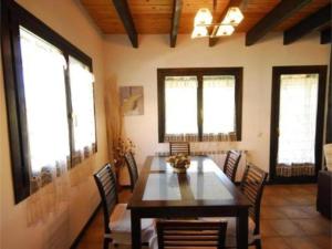 een eetkamer met een tafel, stoelen en ramen bij El Olivar in Palo