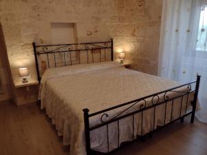 a bedroom with a large bed with two lamps on tables at La casa di pietra in Monopoli