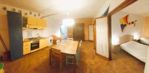 kuchnia i salon z drewnianym stołem w pokoju w obiekcie Villadina Farm w mieście Colico