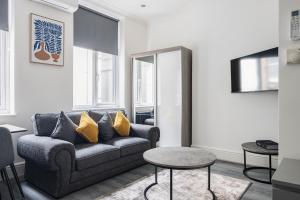 a living room with a couch and a table at Edgware road apartments in London
