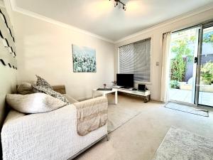a living room with a couch and a tv at Your Oasis in the Heart of East Perth in Perth