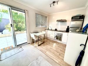 a kitchen with a white refrigerator and a table at Your Oasis in the Heart of East Perth in Perth
