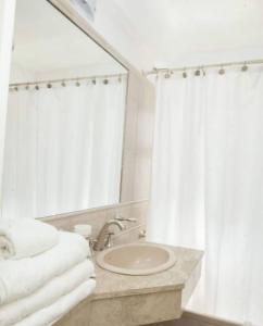 a bathroom with a sink and a mirror and towels at Apartamento Canciller in Buenos Aires