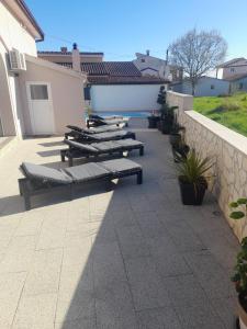 una fila de tumbonas en un patio en Villa Zara, en Poreč