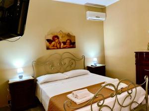 a bedroom with a bed and a painting on the wall at Strelitzia's house with heated pool , private garden and private parking & wi-fi in Avola