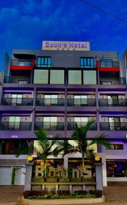 un edificio con un hotel con palme di fronte di Boun's Hotel a Yaoundé