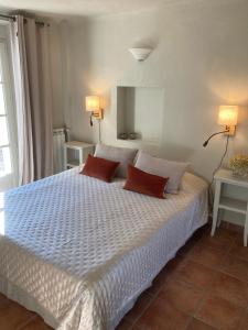 een slaapkamer met een groot bed met 2 rode kussens bij La Bastide de Villecroze in Villecroze