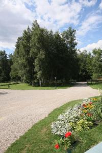 a gravel driveway with flowers in a park at Leśny Dwór in Szczecinek