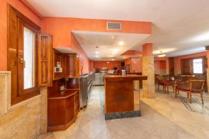 uma cozinha com paredes cor de laranja e uma mesa e cadeiras em H-A Puerta de la Villa em Almazán