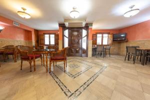 a dining room with a table and chairs and a television at Hostal SIN RECEP24H Puerta de la Villa - Pet friendly & Restaurante in Almazán
