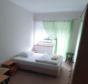 a small bedroom with a bed and a window at Leśny Dwór in Szczecinek