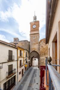un callejón con una torre de reloj en un castillo en H-A Puerta de la Villa, en Almazán