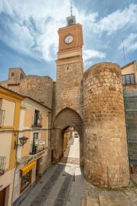 a building with a clock tower and an alley at Hostal SIN RECEP24H Puerta de la Villa - Pet friendly & Restaurante in Almazán +37 photos