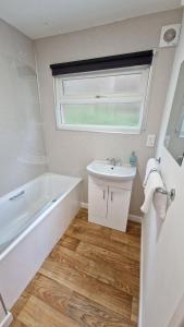 ein Badezimmer mit einem Waschbecken, einer Badewanne und einem Waschbecken in der Unterkunft 6 The Dunes in Braunton
