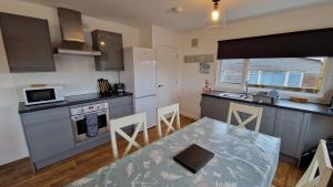 a kitchen with a table and a kitchen with a stove at 6 The Dunes in Braunton