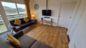 a living room with a couch and a television at 6 The Dunes in Braunton