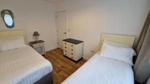 a small bedroom with two beds and a night stand at 6 The Dunes in Braunton