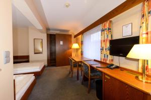 a hotel room with a bed and a desk at APPART-HÔTEL MARCO POLO in Luxembourg