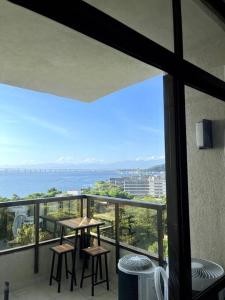 a balcony with a table and stools and a view of the ocean at Apartamento Vista Ponte in Niterói