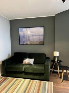una sala de estar con un sofá verde y una foto en Apartamento Vista Ponte, en Niterói