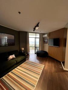a living room with a couch and a television at Apartamento Vista Ponte in Niterói
