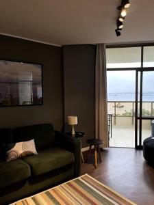 sala de estar con sofá y vistas al océano en Apartamento Vista Ponte, en Niterói
