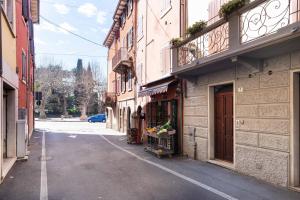 een lege straat met een boodschappenkar aan de zijkant van een gebouw bij Rosmarino Apartment in Garda