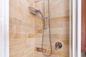 een douche met een douchekop in de badkamer bij Rosmarino Apartment in Garda