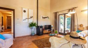 ein Wohnzimmer mit einem Sofa und einem TV in der Unterkunft Na Berganta in Artá