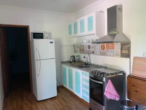 uma cozinha com um frigorífico branco e um fogão em CANDELA casa en balneario Los Pinos II em Fomento