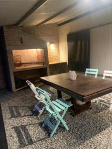 Fomento的住宿－CANDELA casa en balneario Los Pinos II，一间带木桌和两把椅子的用餐室
