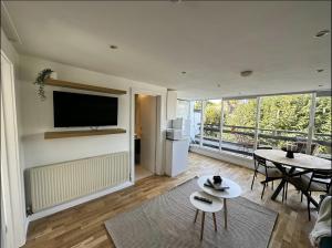 een woonkamer met een televisie en een tafel bij Primrose Hill Apartment with Balcony in Londen