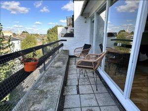 eine Terrasse mit Stühlen und einem Tisch auf dem Balkon in der Unterkunft Primrose Hill Apartment with Balcony in London