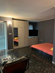 1 dormitorio con 1 cama, escritorio y TV en Guest House Dobrev, en Kardzhali