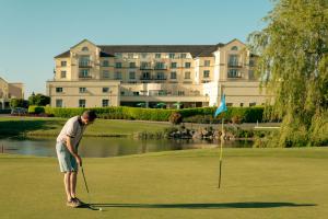un homme joue au golf sur un parcours dans l'établissement Knightsbrook Hotel & Golf Resort, à Trim