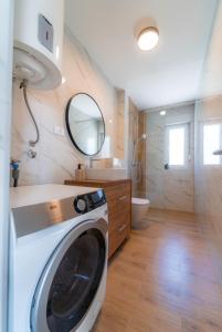 uma máquina de lavar roupa na casa de banho com um espelho em Apartman Dvor em Podstrana