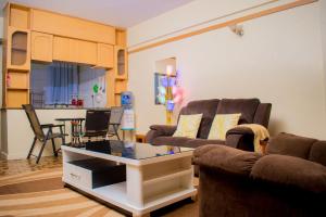 a living room with two couches and a table at G&G Homes Executive 2 bedroom Town Apartment in Eldoret +36 photos