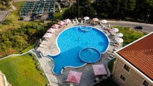 布德瓦Apartman DELUXE的享有带遮阳伞的大型游泳池的顶部景致