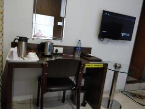 a desk with a chair and a television in a room at Hotel Royal Shelter Vapi in Vapi