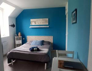 een slaapkamer met een blauwe muur en een bed bij LE RUN AR MOR 22 in Bas Kerhain