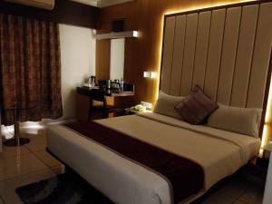 1 dormitorio con 1 cama grande en una habitación en Hotel Royal Shelter Vapi, en Vapi