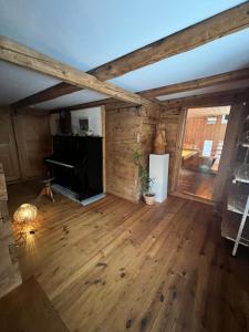 um quarto vazio com pisos em madeira e um piano em Alpen Oase Natur em St. Gallen
