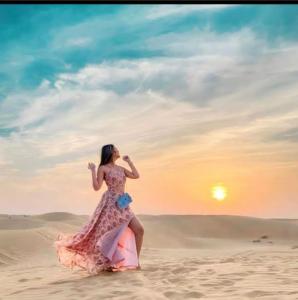 a woman in a dress walking in the desert at Desert Malra Camp in Jaisalmer