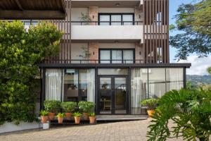 a house with glass doors and potted plants at Camp David Ranch in Santiago de los Caballeros