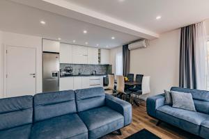 a living room with a blue couch and a kitchen at Bečići lux in Bečići