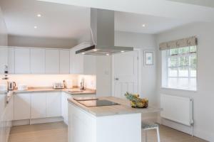 a kitchen with white cabinets and a sink at Peaceful Woodland Retreat near Clifton, Bristol in Bristol