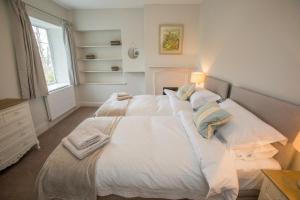 a bedroom with two beds with white sheets at Peaceful Woodland Retreat near Clifton, Bristol in Bristol