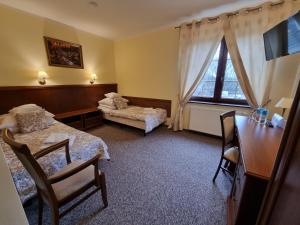 a hotel room with two beds and a window at Hotel Bończa in Szczecin