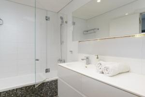 a white bathroom with a sink and a mirror at Jerusalem Holiday Luxury Home by FeelHome in Jerusalem